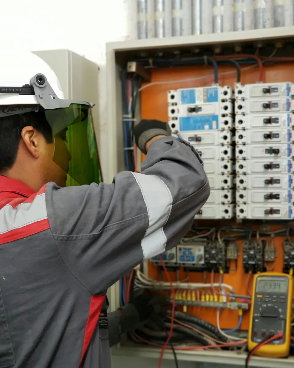 Técnico revisando un tablero eléctrico con multímetro